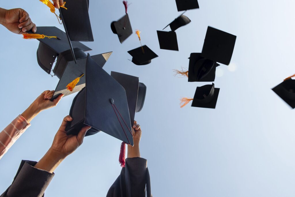 cropped hands of people throwing mortarboards royalty free image 1649367603